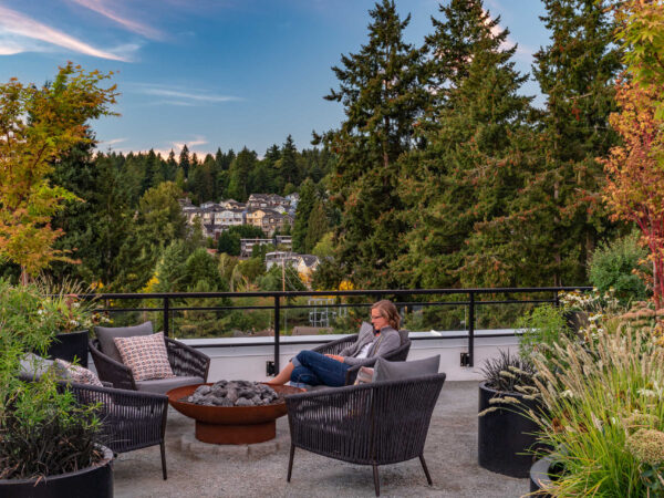 woman reading by firepit in a lounge chair